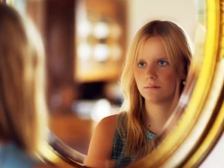 woman looking in mirror feeling ugly husband won't touch