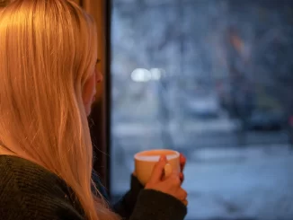 woman looking out window upset her husband uses her