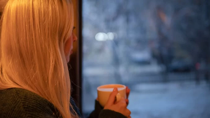 woman looking out window upset her husband uses her